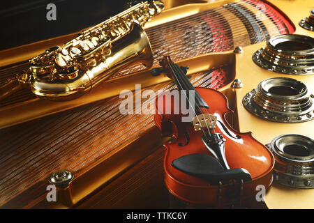Violin and saxophone lying on piano, close up Stock Photo