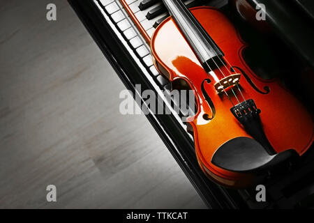 Violin lying on piano keys, close up Stock Photo
