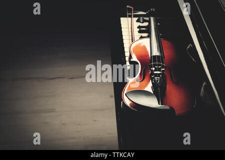Violin lying on piano keys, close up Stock Photo