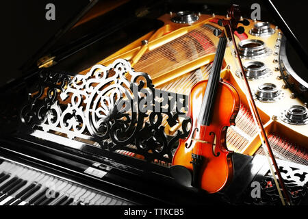 Violin lying on piano, close up Stock Photo