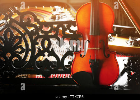 Violin lying on piano, close up Stock Photo
