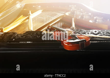 Violin lying on piano, close up Stock Photo