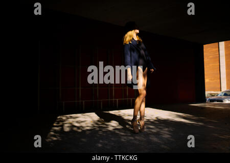 Woman ballerina standing in the shade on the street Stock Photo