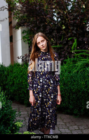 Woman standing near the bushes boxwood Stock Photo
