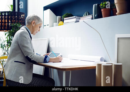 Female architect working while using tablet in office Stock Photo