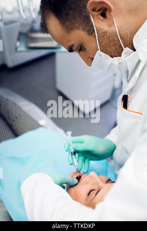 Dentist giving injection to patient at clinic Stock Photo