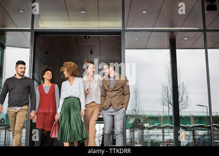 Happy business people leaving restaurant Stock Photo