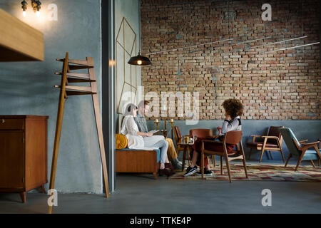 Creative business people discussing in hotel lobby Stock Photo