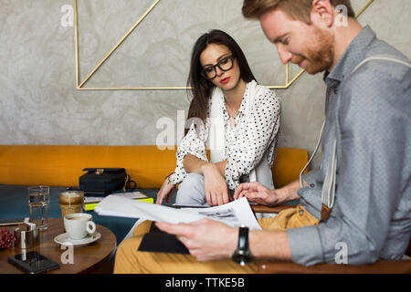 Business colleagues analyzing documents at hotel lobby Stock Photo