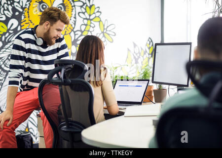 business colleagues using laptop in creative office Stock Photo