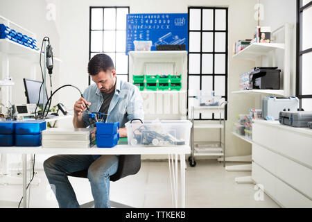Engineer working on circuit board at table in electronic laboratory Stock Photo
