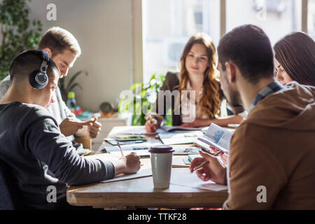 Students studying at table in classroom Stock Photo