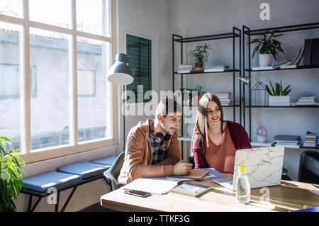 Students using laptop computer while sitting at table in classroom Stock Photo
