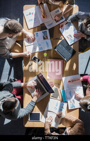 Overhead view of friends studying at table in college Stock Photo