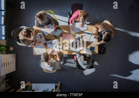 Overhead view of students studying at table in classroom Stock Photo