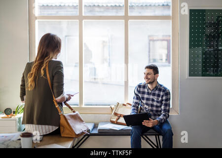 Man looking at friend while sitting in classroom Stock Photo