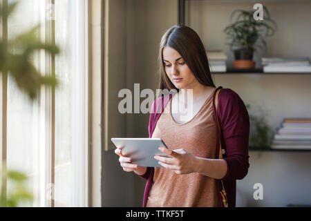 Woman using tablet computer while standing in classroom Stock Photo