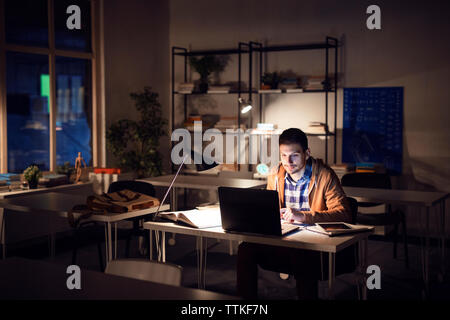 Confident student studying in library at night Stock Photo