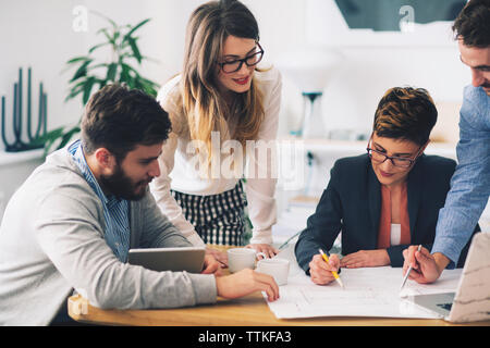 business people discussing blueprints in office Stock Photo