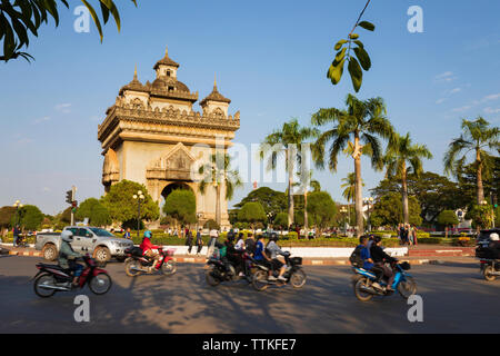 Mopeds riding past the Patuxai Victory Monument (Vientiane Arc de Triomphe), Vientiane, Laos, Southeast Asia