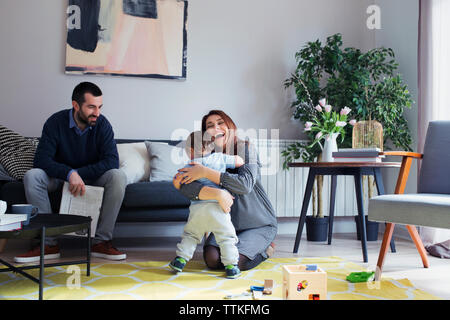 Man looking at son embracing mother at home Stock Photo