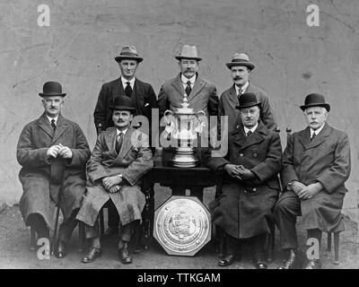 A vintage black and white photograph showing members of the English Football Association with the FA Cup trophy and Charity Shield. Photograph taken during the 1920s or 1930s. Stock Photo