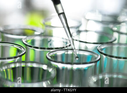 Pipette dripping liquid into test tube Stock Photo