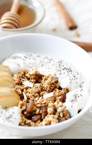 Close-up of sliced apple and yogurt in breakfast cereals on table Stock Photo