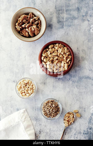 High angle view of various nuts in bowls on table Stock Photo