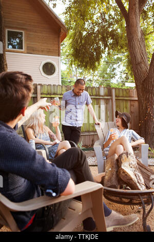 Cheerful friends having drinks in yard Stock Photo