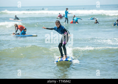 Full length of girl surfing on sea Stock Photo