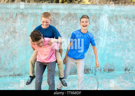 Youngest brother jumps on older brother's back for a piggyback Stock Photo