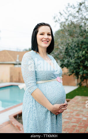 Pretty pregnant woman portrait in front of a swimming pool Stock Photo