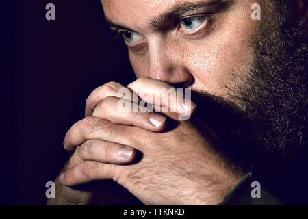 Close-up of serious man against black background Stock Photo