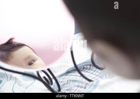 Reflection of cute baby girl seen in mirror at home Stock Photo