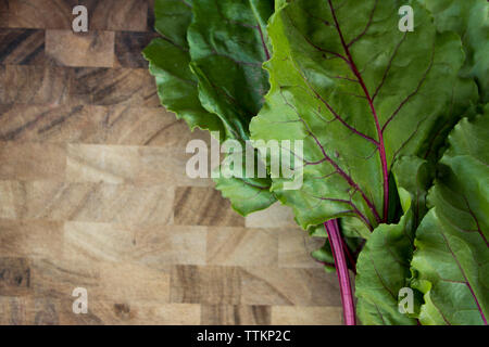 Overhead view of beetroot leaves on wooden table Stock Photo