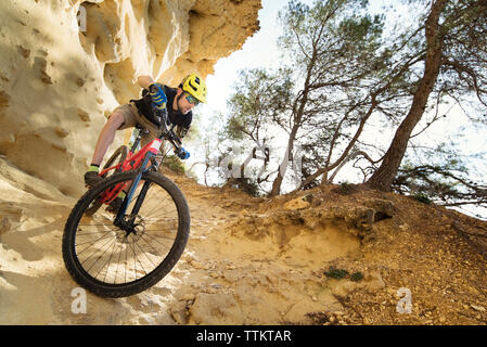 Cyclist descending through a very technical area of sandstone Stock Photo