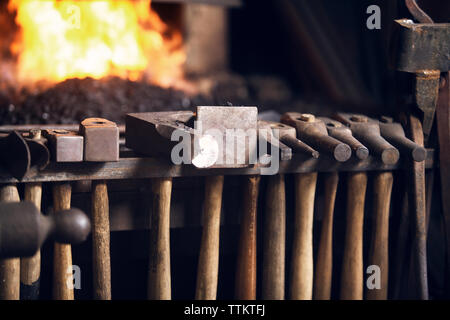 Various hammers hanging on rack in blacksmith shop Stock Photo