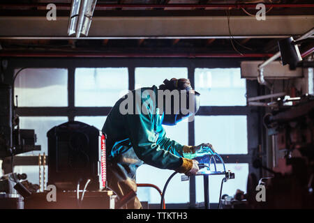 Worker using welding torch in workshop Stock Photo