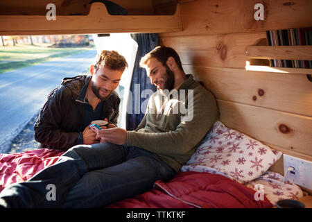 Man showing smart phone to friend Stock Photo