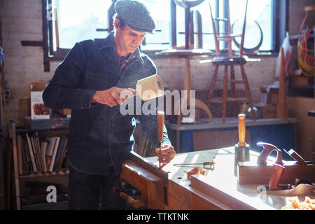 Carpenter using chisel and mallet at workshop Stock Photo