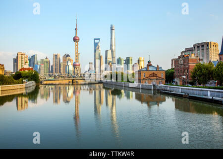 Modern buildings by Huangpu River against blue sky during sunset Stock Photo