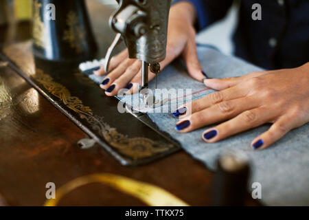 Cropped image of woman using sewing machine Stock Photo