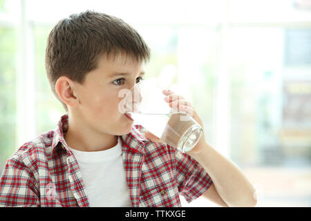 Cute boy drinking water on kitchen Stock Photo