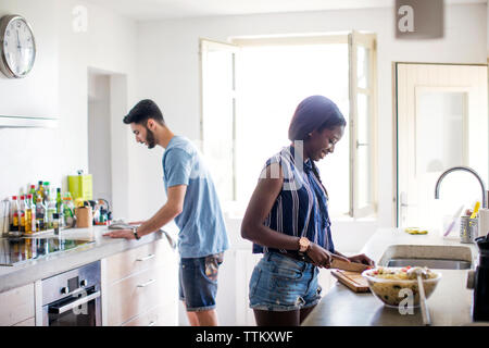 Side view of couple working in kitchen Stock Photo