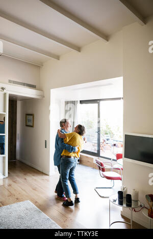 Side view of happy senior couple dancing at home Stock Photo