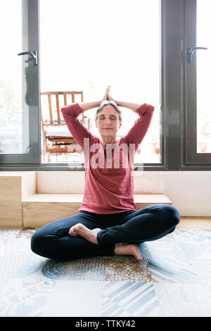 Mature woman doing yoga at home Stock Photo