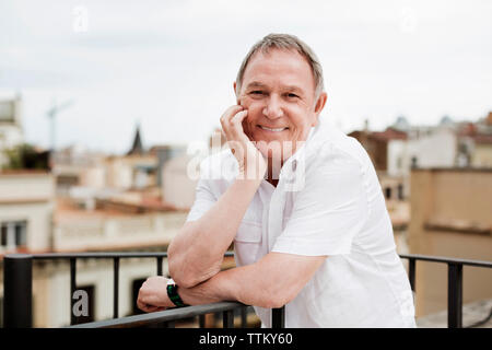 Portrait of happy senior man standing on terrace Stock Photo