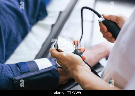 Close-up of doctor checking patient pulse at hospital Stock Photo