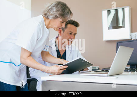 Doctors working at table in hospital Stock Photo